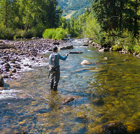 man fly fishing in river