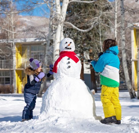 Children building a snowman together