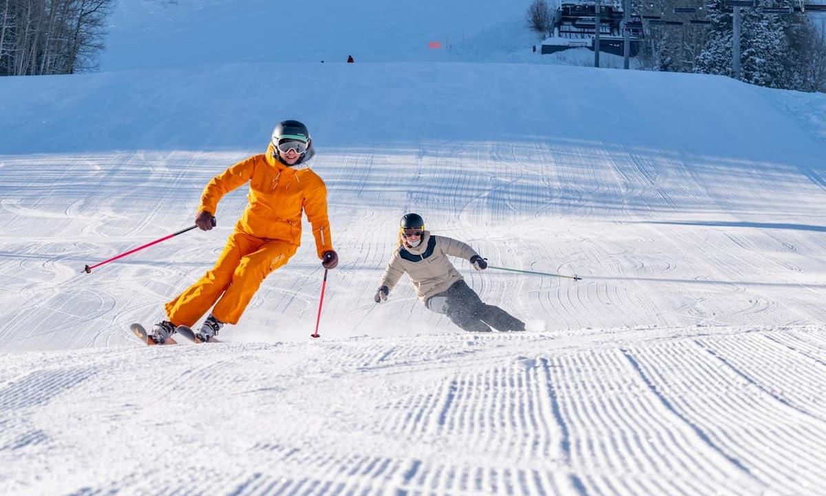 two skiers coming down the mountain