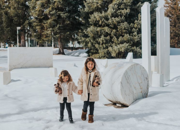 children outside in front of marble statue