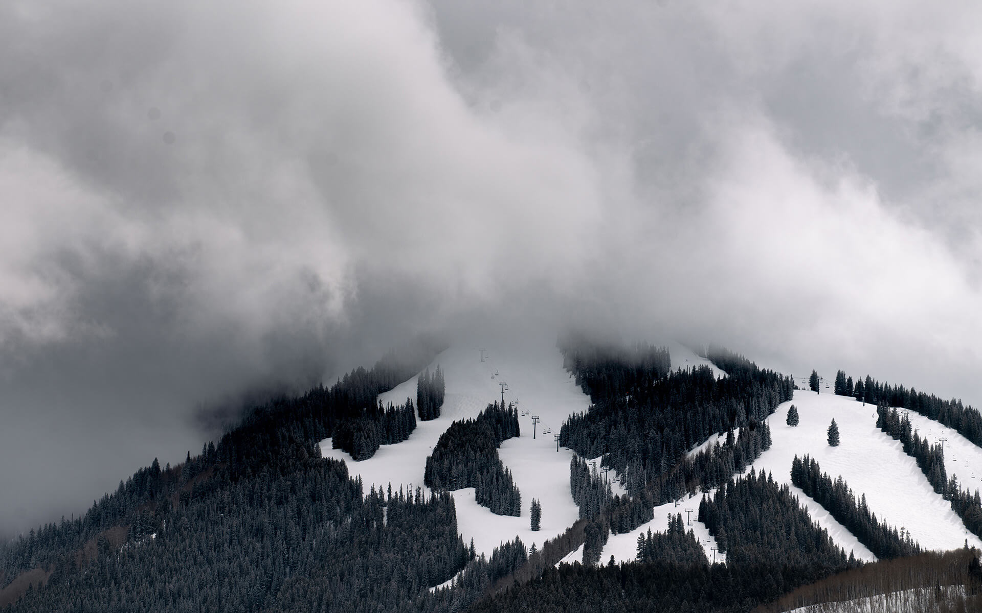 Snow capped mountainside view with clouds